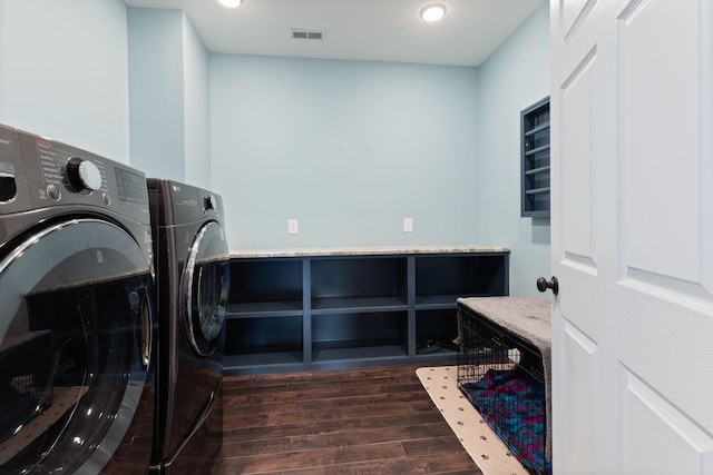 laundry room with washing machine and clothes dryer, dark wood-type flooring, and recessed lighting