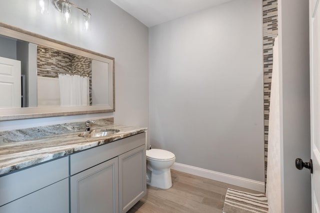 full bathroom featuring wood finished floors, toilet, baseboards, vanity, and a shower with curtain