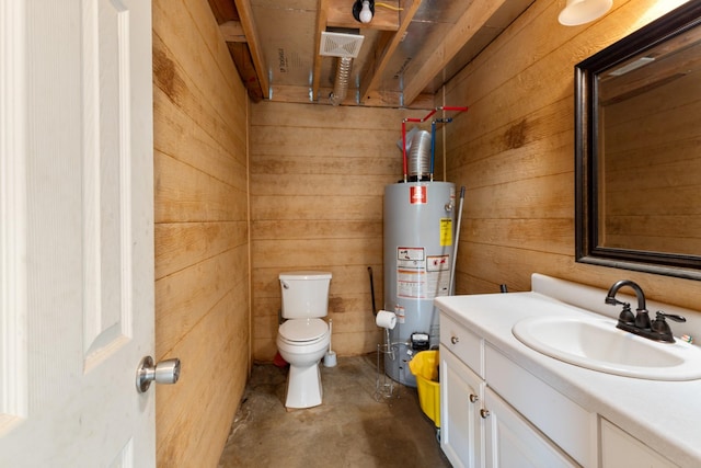 bathroom with water heater, wooden walls, concrete floors, toilet, and vanity