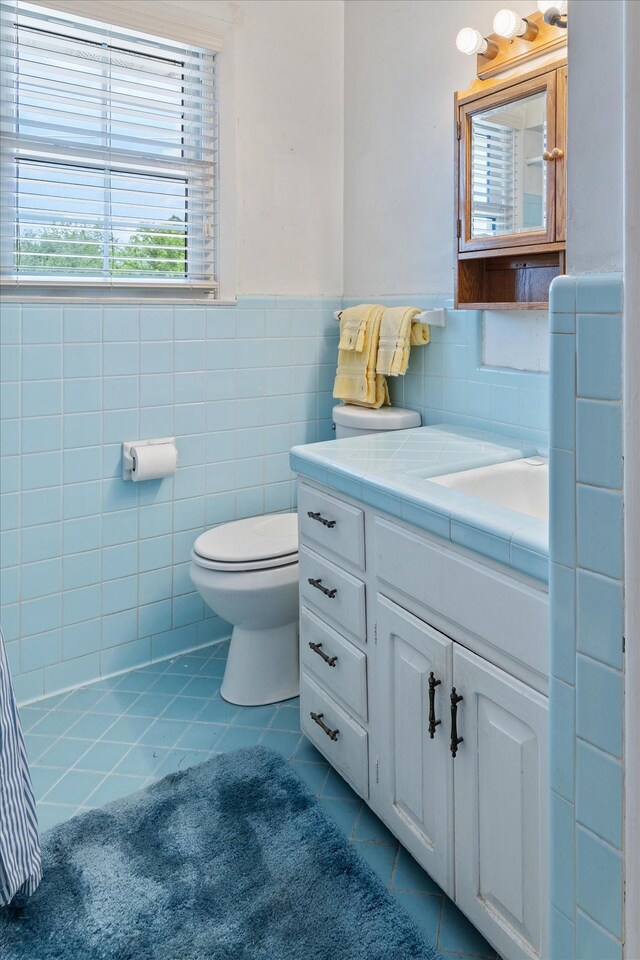 461 Annex Ave, Nashville, TN 37209 - bathroom with tile patterned floors, tile walls, toilet, vanity, and a wainscoted wall