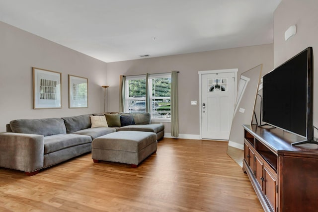 living area featuring light wood-style floors and baseboards