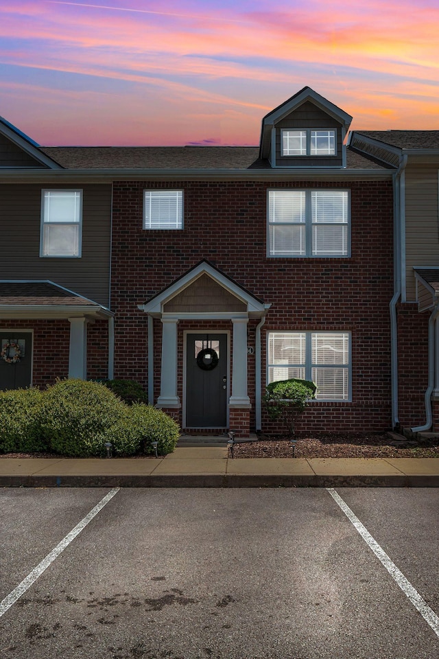 multi unit property with uncovered parking and brick siding