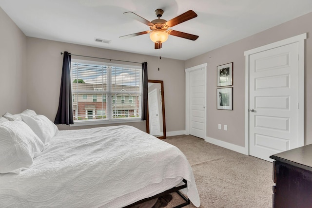 bedroom featuring light colored carpet, baseboards, and ceiling fan