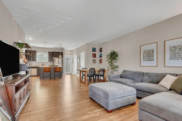 living room with light wood-style flooring and recessed lighting