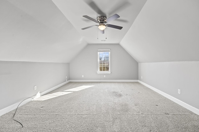 bonus room featuring lofted ceiling, carpet flooring, baseboards, and a ceiling fan