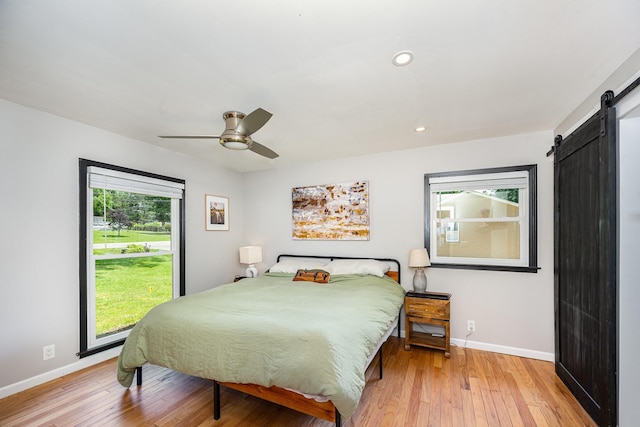 112 Churchill Pl, Franklin, TN 37067 - bedroom featuring a barn door, multiple windows, light wood-type flooring, and recessed lighting