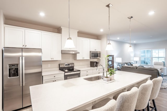 124 Great Falls Ct, Gallatin, TN 37066 - kitchen with appliances with stainless steel finishes, a sink, a center island with sink, a breakfast bar, and white cabinets