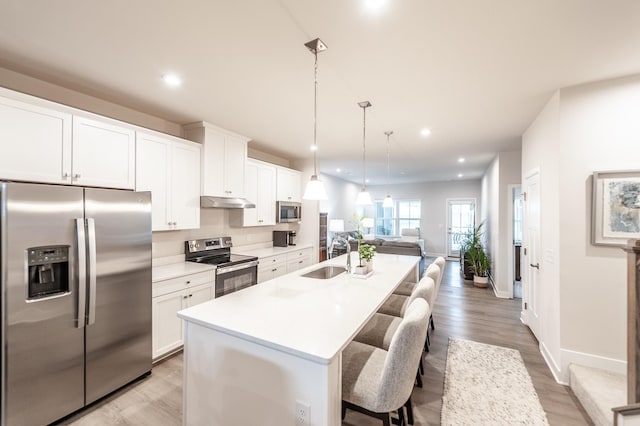 124 Great Falls Ct, Gallatin, TN 37066 - kitchen with stainless steel appliances, a sink, open floor plan, a kitchen island with sink, and a kitchen breakfast bar