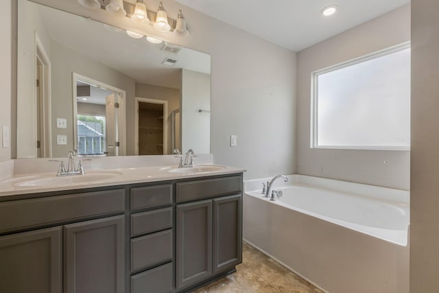 bathroom with a garden tub and double vanity