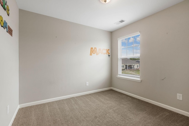 carpeted empty room featuring baseboards