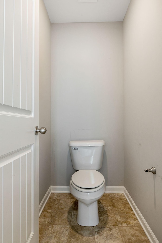 bathroom with toilet and baseboards