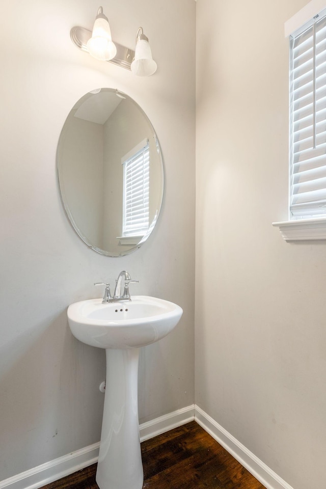 bathroom featuring wood finished floors, baseboards, and a sink