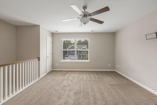 empty room with carpet flooring, ceiling fan, and baseboards