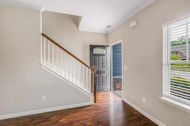 foyer entrance featuring ornamental molding, baseboards, wood finished floors, and stairway