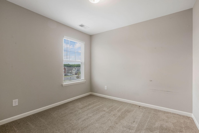 empty room featuring light colored carpet and baseboards