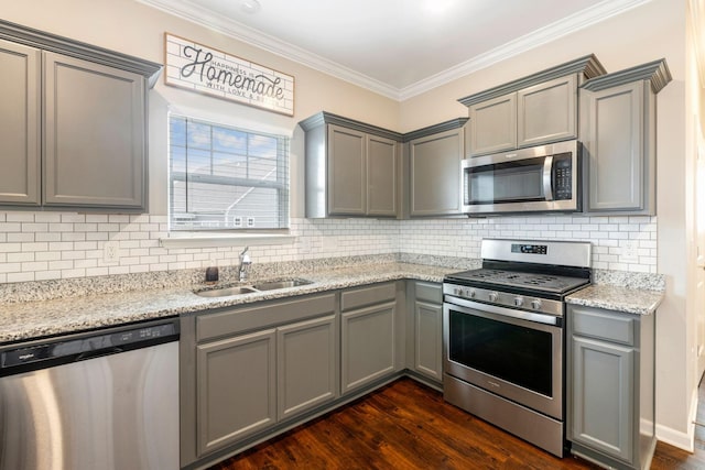 kitchen featuring appliances with stainless steel finishes, gray cabinets, crown molding, and a sink