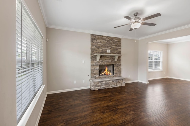 unfurnished living room featuring a ceiling fan, dark wood finished floors, crown molding, a fireplace, and baseboards