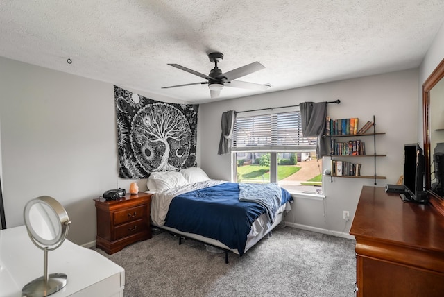 carpeted bedroom featuring baseboards, a textured ceiling, and ceiling fan