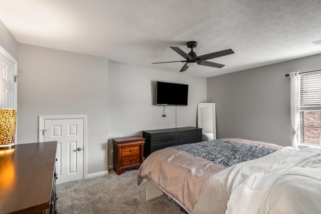 carpeted bedroom featuring a textured ceiling and a ceiling fan