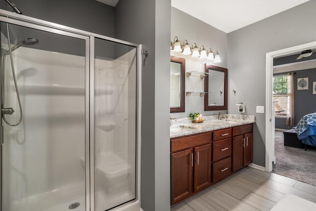 bathroom with a shower stall, connected bathroom, and double vanity