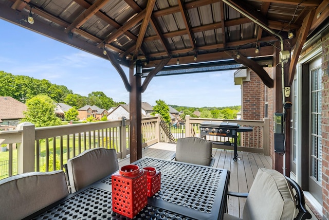 wooden deck with a gazebo and outdoor dining space