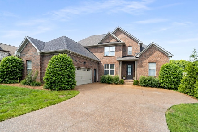 view of front of property featuring brick siding, driveway, an attached garage, a front lawn, and roof with shingles
