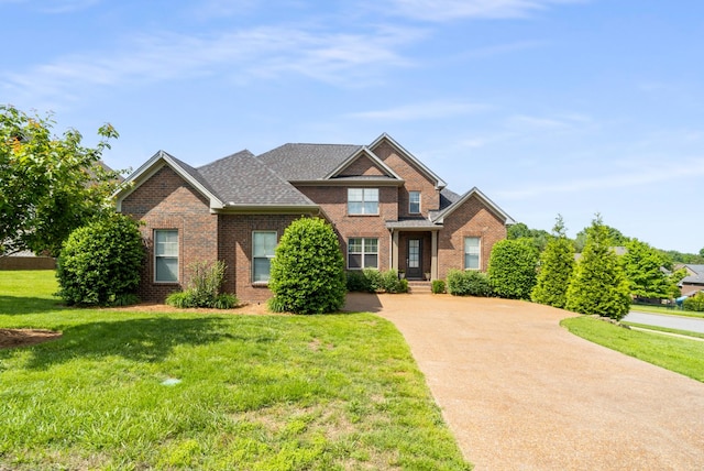 traditional-style home featuring brick siding, a front yard, and driveway