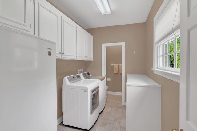 washroom with washer and clothes dryer, cabinet space, and baseboards