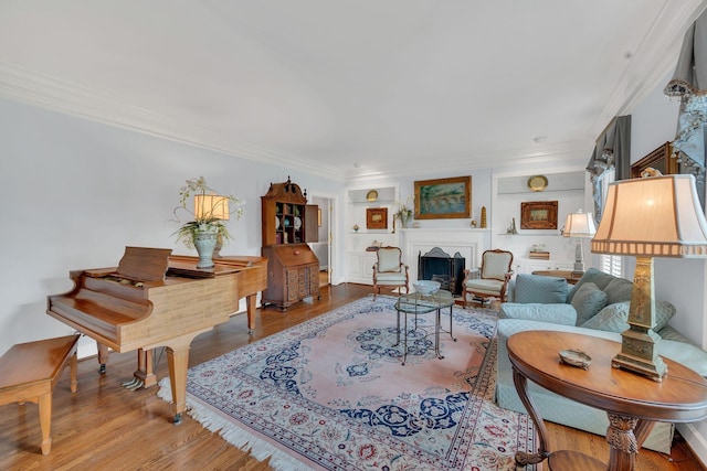 living area with ornamental molding, a fireplace, and wood finished floors