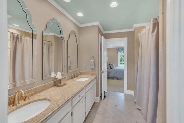 ensuite bathroom with double vanity, tile patterned floors, baseboards, ornamental molding, and recessed lighting