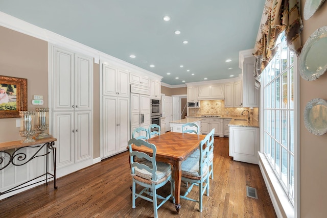 dining area featuring wood finished floors, plenty of natural light, recessed lighting, and crown molding