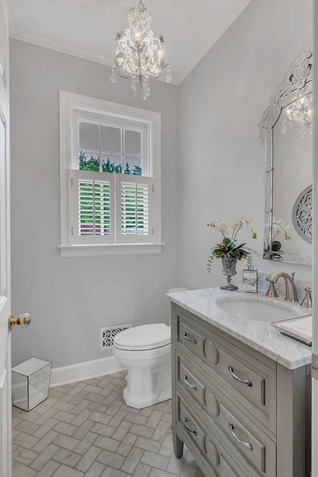 half bath with brick patterned flooring, ornamental molding, a chandelier, vanity, and toilet