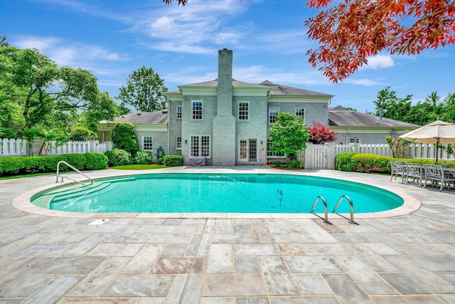 view of swimming pool with a patio and fence