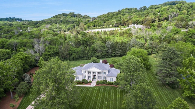 view of property location with a forest