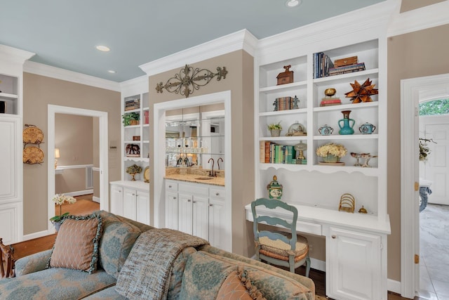 living area featuring built in shelves, ornamental molding, baseboards, and recessed lighting