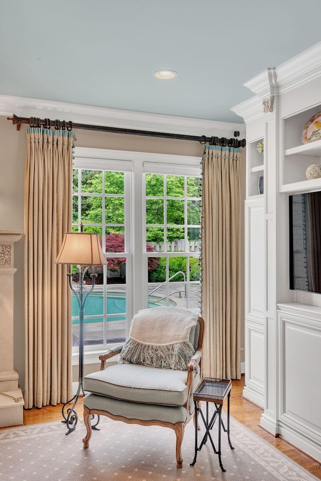 sitting room featuring ornamental molding, healthy amount of natural light, and light wood-type flooring