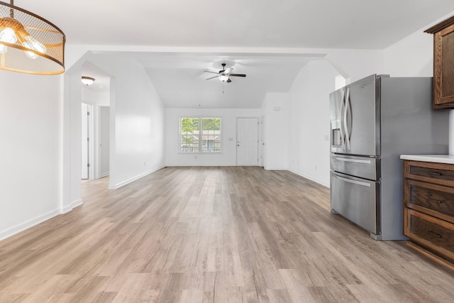 unfurnished living room with vaulted ceiling, a ceiling fan, light wood-style floors, and baseboards
