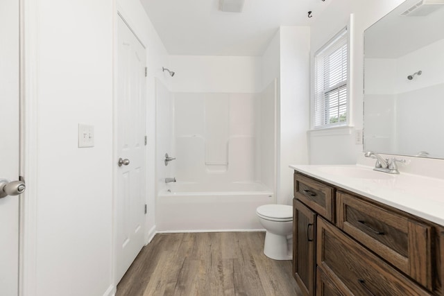 full bath featuring wood finished floors, toilet, bathing tub / shower combination, and vanity