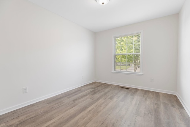 empty room featuring light wood-style floors and baseboards