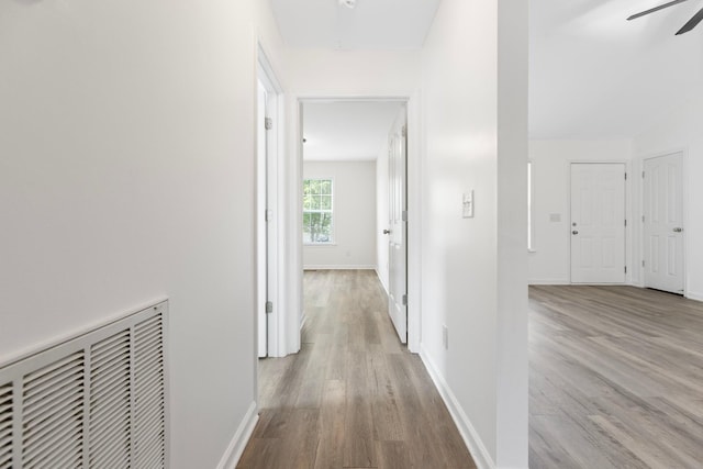 corridor featuring wood finished floors and baseboards