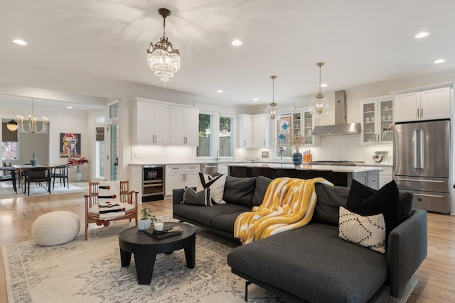 living area with a chandelier, recessed lighting, and light wood-style flooring