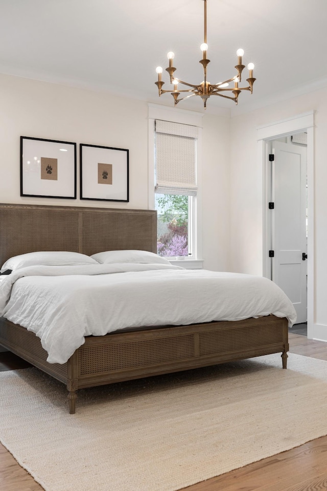 bedroom with a chandelier and wood finished floors