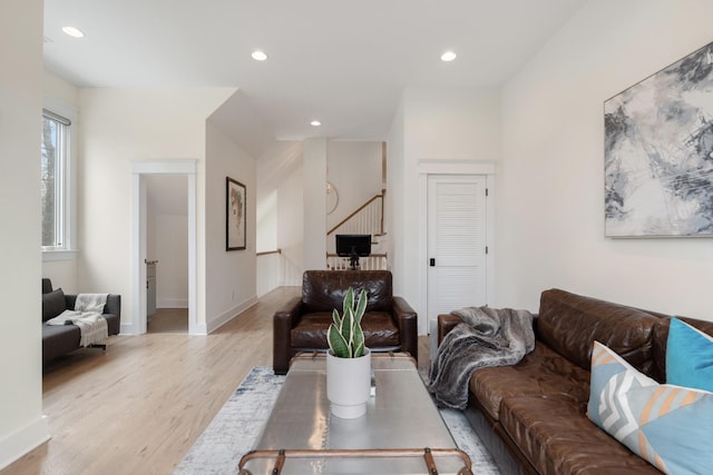 living room with light wood-style flooring, recessed lighting, baseboards, and stairway