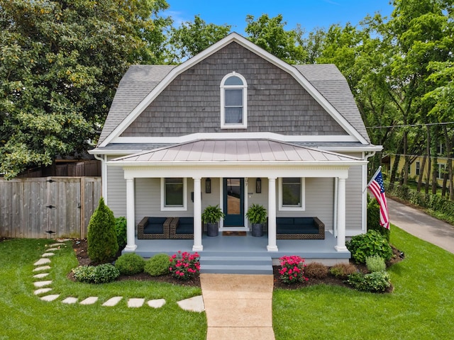 colonial inspired home featuring a standing seam roof, a porch, metal roof, and roof with shingles