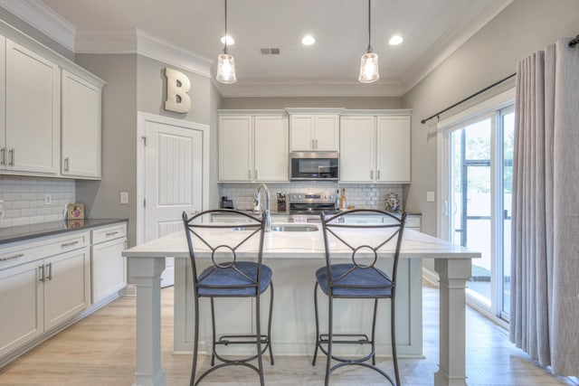 kitchen with stainless steel appliances, a breakfast bar area, decorative backsplash, ornamental molding, and recessed lighting