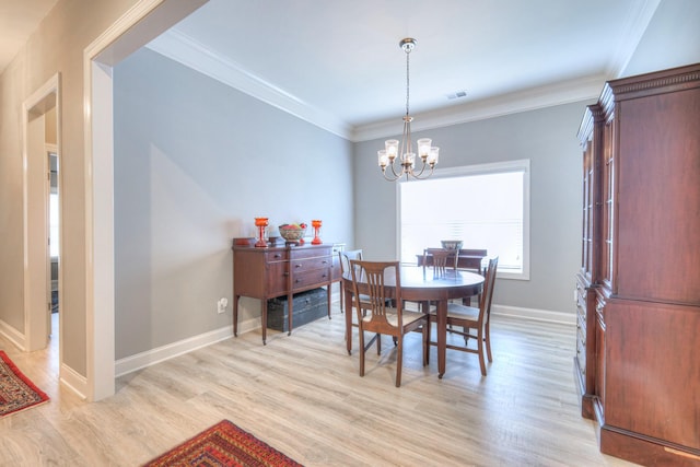 dining space featuring a chandelier, light wood-style flooring, baseboards, and crown molding