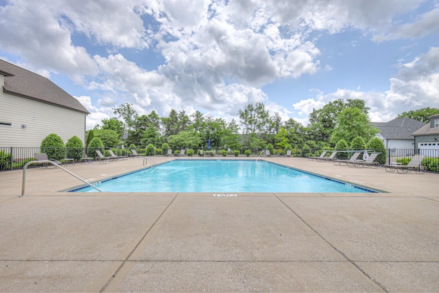 community pool featuring fence and a patio