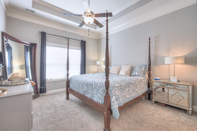 bedroom with crown molding, light colored carpet, baseboards, a tray ceiling, and ceiling fan