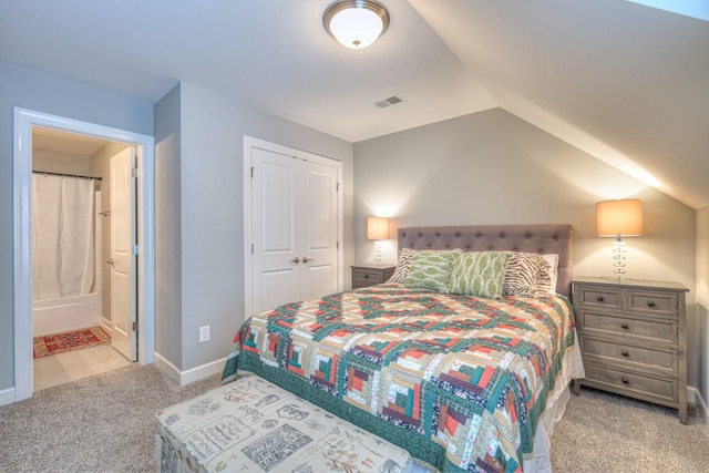 bedroom with carpet, lofted ceiling, a closet, baseboards, and ensuite bathroom