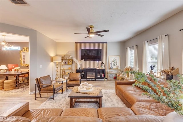living area with light wood-style flooring and ceiling fan